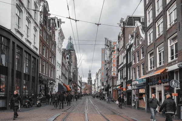 Arka planında Munttower 'ın bulunduğu dükkanları, kafeteryaları ve restoranları bulunan Amsterdam' ın eski bir kasabasında düzenli olarak bulunuyordu.