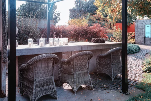 Большой украшенный бетонный стол, покрытый стеклянной беседкой в осеннем саду — стоковое фото