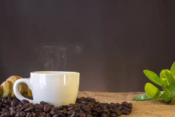 Tasse blanche et grains de café et fond sombre Images De Stock Libres De Droits