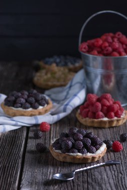 Berry mini turta peçete ve kova ahududu ahşap tablo.