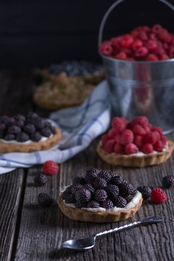 Berry mini turta peçete ve kova ahududu ahşap tablo.