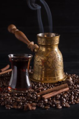 Bakır Jezve ve kahve çekirdekleri ve siyah arka plan üzerine baharat.