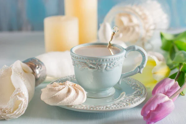 Tulip Eflatun ve beyaz peçete ahşap zemin üzerine açık mavi Çin kupada sütlü kahve.