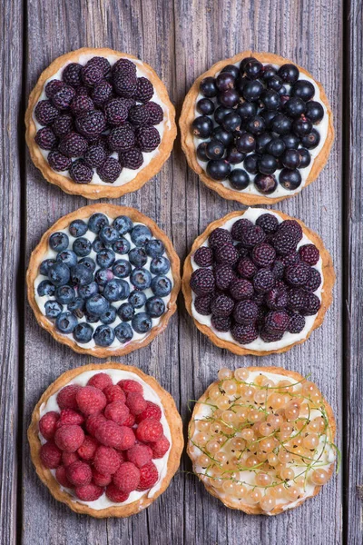 Ahşap masa, üstten görünüm üzerinde Berry mini turta.