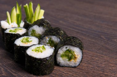 Siyah ormanlık zemin üzerine avokado suşi.