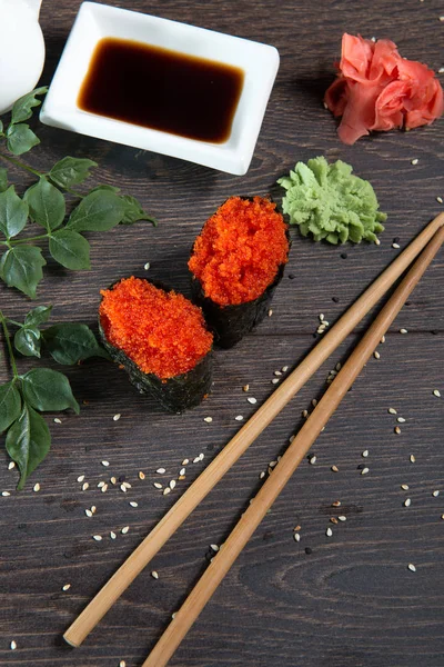 Tobiko-flying fish roe sushi. Japanese rice roll with seaweed at sushi bar