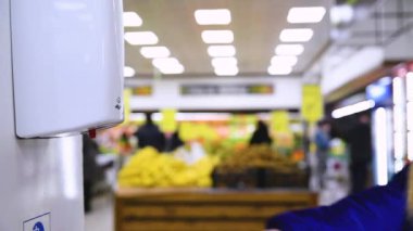 Markette el dezenfektanı. İnsanlar alışverişten önce ellerini sterilize eder.