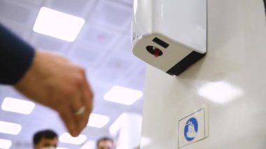 Markette el dezenfektanı. İnsanlar alışverişten önce ellerini sterilize eder.
