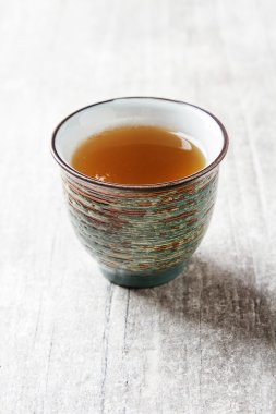 Seramik kupa yeşil çay ve lepistkami gül ile. Koyu arka plan