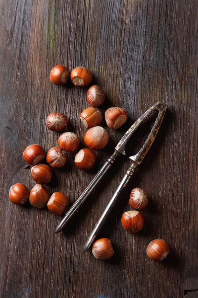 Group ripe hazelnuts with Nutcracker. Dark wood background. Top — Stock Photo, Image