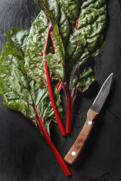 Swiss rainbow chard, vibrant vegetable. Flat lay, knife from abo