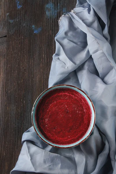 Sopa de remolacha tradicional en un plato azul. Fondo de madera oscura . —  Fotos de Stock