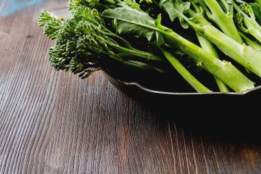 Metal bir tabakta taze yeşil brokoli. Koyu ahşap arka plan. Spa