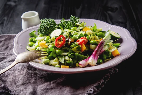 Čerstvý zelený salát s fazolemi, červenou cibulkou, sýrem čedar a sauc — Stock fotografie
