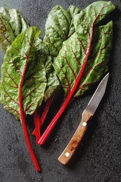 Swiss rainbow chard, vibrant vegetable. Flat lay, knife from abo
