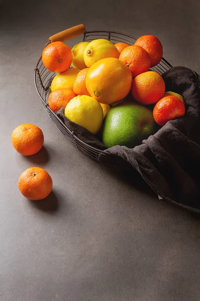 灰色の背景にバスケットの異なる新鮮な柑橘系の果物。M — ストック写真