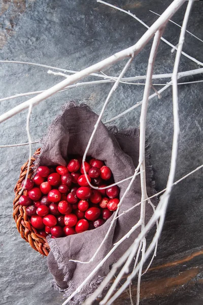 Red berries on a dark background. cranberries in a wicker basket — Stock Photo, Image