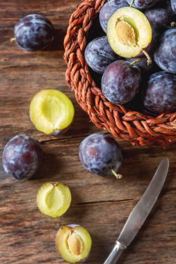 Olgun Erik kahverengi ahşap zemin üzerinde dağınık. Biyo sağlıklı f