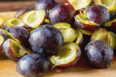 Olgun Erik kahverengi ahşap zemin üzerinde dağınık. Biyo sağlıklı f