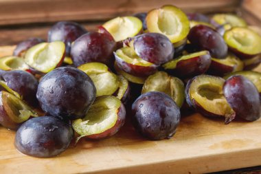 Olgun Erik kahverengi ahşap zemin üzerinde dağınık. Biyo sağlıklı f