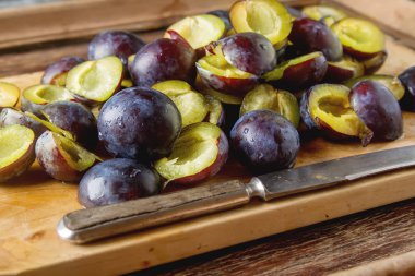 Olgun Erik kahverengi ahşap zemin üzerinde dağınık. Biyo sağlıklı f