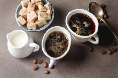 Beyaz fincan sıcak siyah kahve süt ve şeker. Gri backgrou