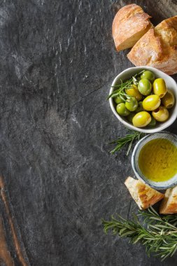 Olivier petrol taze otlar ve ekmek. Gri arka plan. İtalyanca