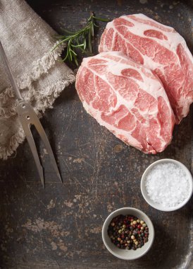 Çiğ domuz biftek - otlar ile yemek pişirmek için hazır. Gri arka planı. 