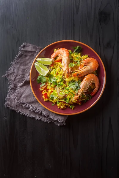 İspanyol paella deniz ürünleri üzerine kireç ile kırmızı teralke ile. Delici