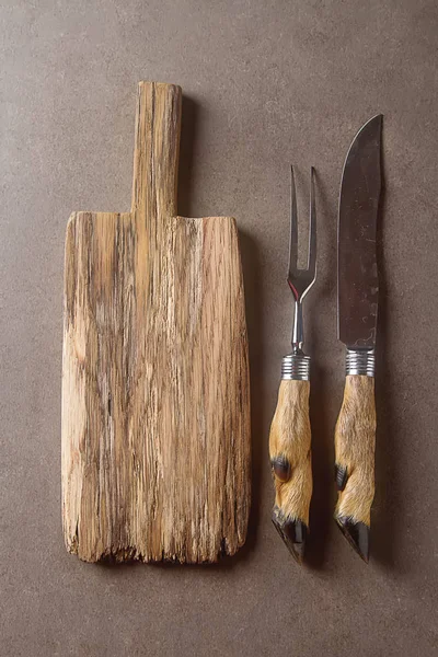Corte de tabla de cortar, con tenedor y cuchillo tallado en oscuro — Foto de Stock