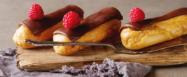 Traditional French dessert. Eclair with chocolate icing and rasp