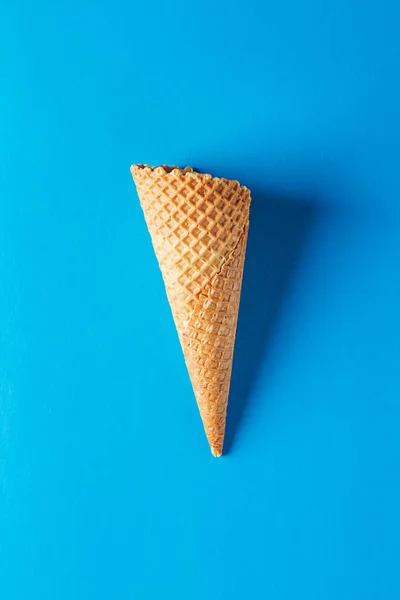 Um simples cone de gelado. Fundo azul. Espaço para SMS. Vista superior — Fotografia de Stock