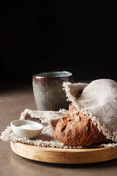 Fresh homemade French black bread. Dark background. — Stock Photo, Image