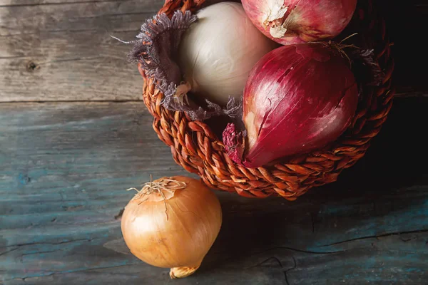 Cebolas de diferentes variedades e cores. Fundo cinza escuro . — Fotografia de Stock