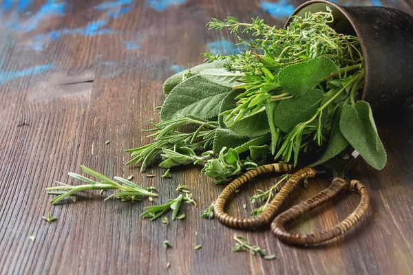 Mix of fresh Italian herbs from garden on an old table. Rosemary