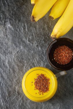 Taze ev yapımı smoothie muz ile quinoa. Koyu arka plan.