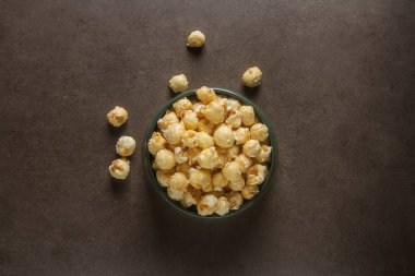 Bir kase tatlı patlamış mısır. Gri arka plan. Bir film izlemek.