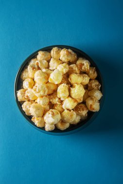 Bir kase tatlı patlamış mısır. parlak arka plan. Bir film izlemek.