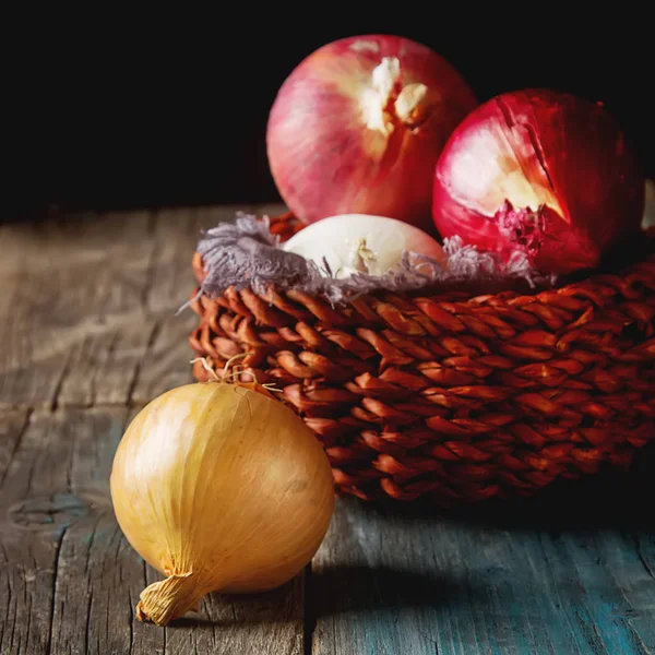 Cebolas de diferentes variedades e cores. Fundo cinza escuro . — Fotografia de Stock