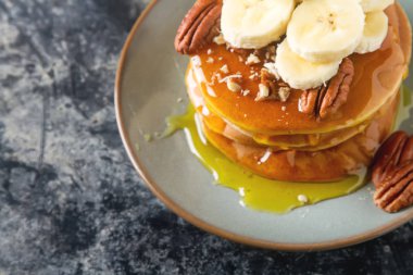 Amerikan krep yerken üzerine bir tabak muz ve fındık, tatlı sos ile. 