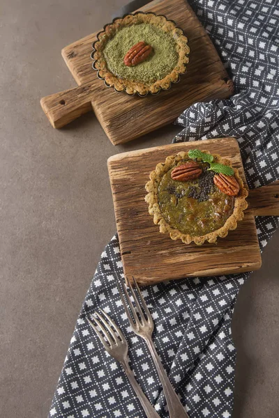 Green tea vegetarian pie match with nuts and mint. Dark backgrou