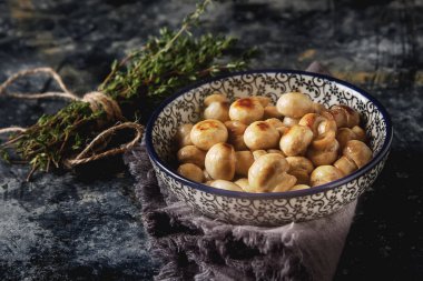 Mantar kekik ile bir tabak kızarmış. Koyu arka plan.