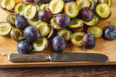 Olgun Erik kahverengi ahşap zemin üzerinde dağınık. Biyo sağlıklı f