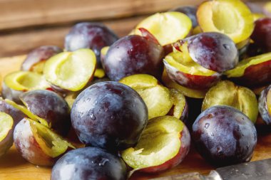 Olgun Erik kahverengi ahşap zemin üzerinde dağınık. Biyo sağlıklı f