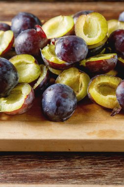 Olgun Erik kahverengi ahşap zemin üzerinde dağınık. Biyo sağlıklı f