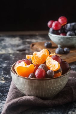 Mandarin, üzüm, yaban mersini meyve salatası ile plaka. Lezzetli 