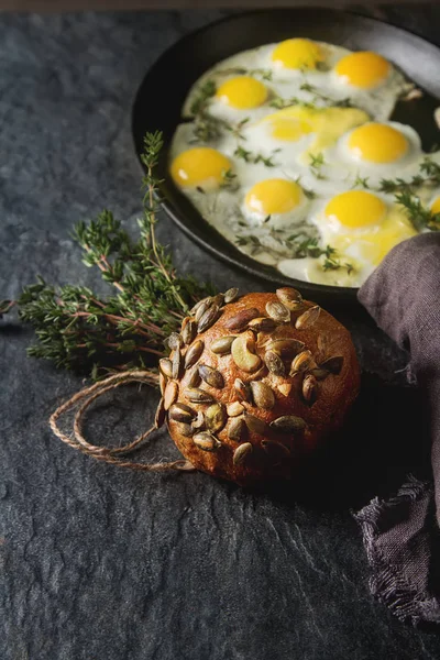 Huevos fritos de codorniz en una sartén con tomillo. Fondo oscuro . — Foto de Stock