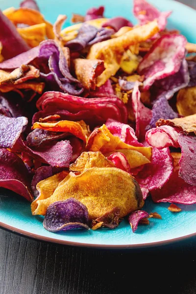 Beet and carrot salty chips in an old blue plate. Dark wood back — Stock Photo, Image