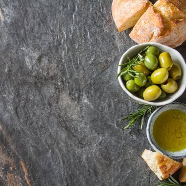 Olivier petrol taze otlar ve ekmek. Gri arka plan. İtalyanca