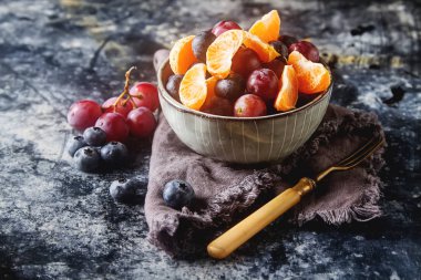Mandarin, üzüm, yaban mersini meyve salatası ile plaka. Lezzetli 